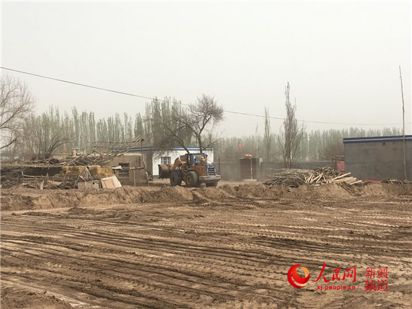 新疆大學科學技術學院駐村工作隊幫助村民清理庭院。王海輝 攝