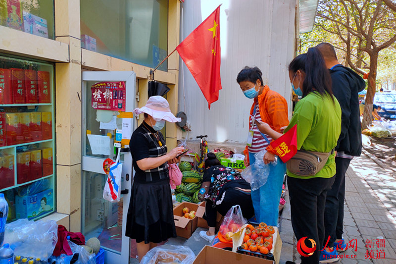 29日，烏魯木齊市天山區西后街，商鋪開門營業，居民出門購物。薩妮婭 攝