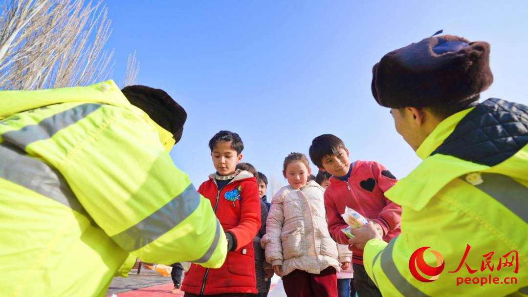 1月24日上午，乌什县亚曼苏乡中心幼儿园安置点，民警为孩子们发放牛奶和面包等零食。人民网 李欣洋摄