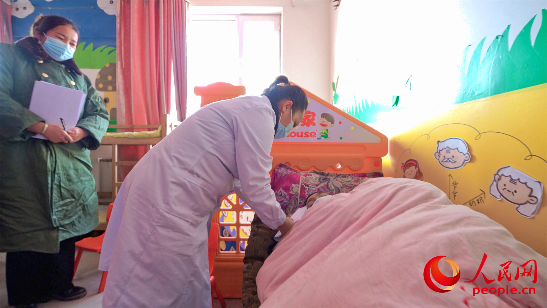 1月24日上午，乌什县亚曼苏乡中心幼儿园安置点，一名医护人员正在工作。人民网 李欣洋摄