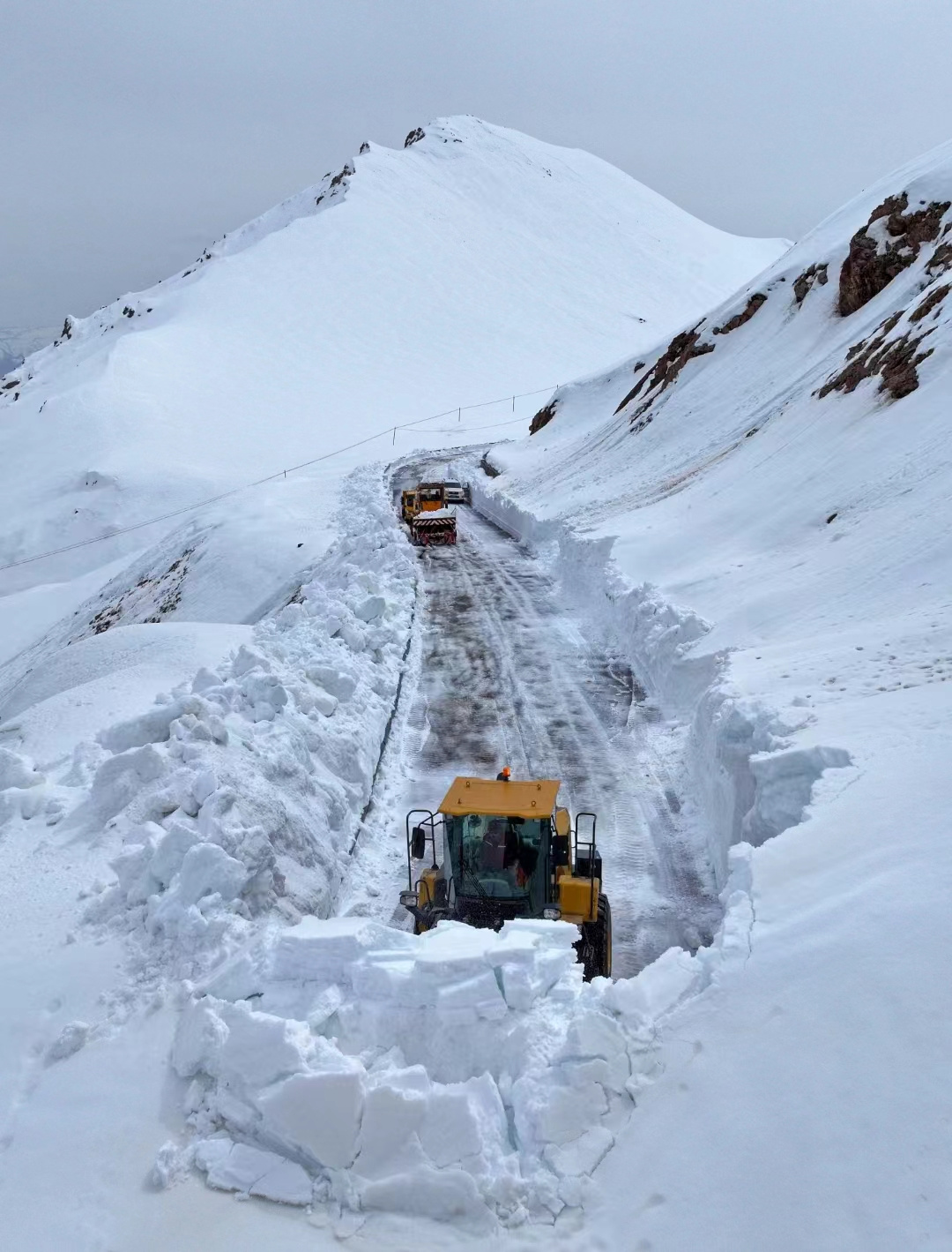 封闭中的独库公路上，伊犁公路管理局那拉提分局的护路工人正在进行除雪作业。雷声摄
