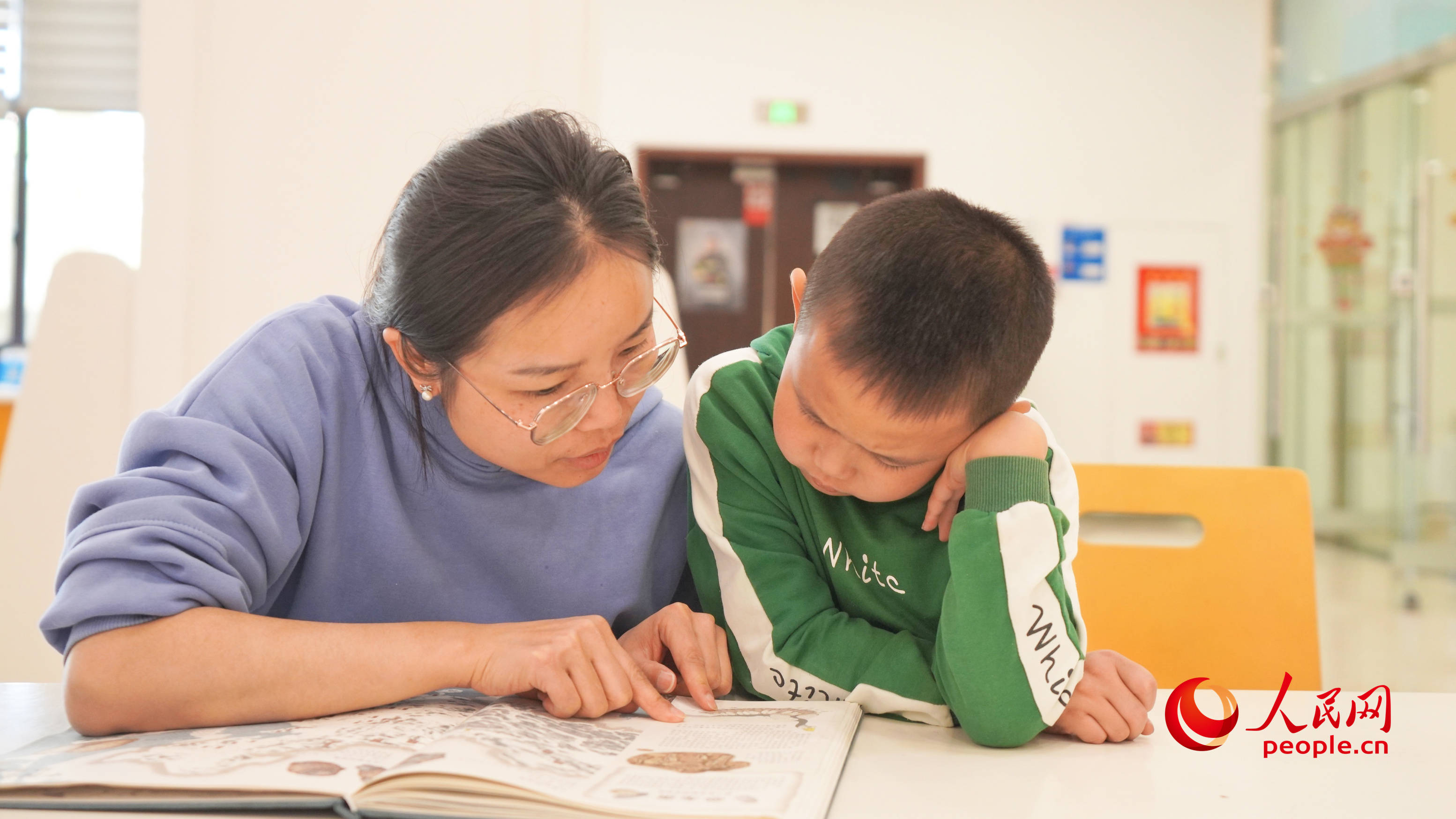 4月23日，在新疆图书馆，不少家长带着孩子一起看书。人民网 李龙摄