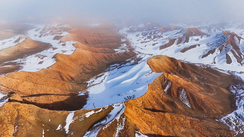 白雪皚皚映丹霞 山巒疊嶂景如畫