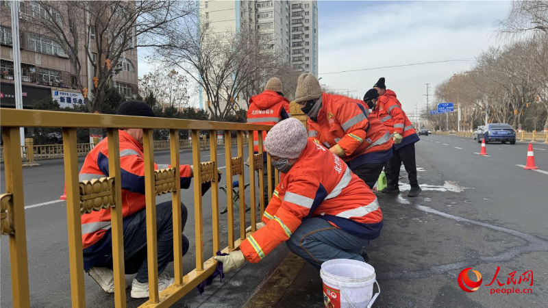 环卫工人擦拭道路隔离护栏。人民网 娜地拉摄