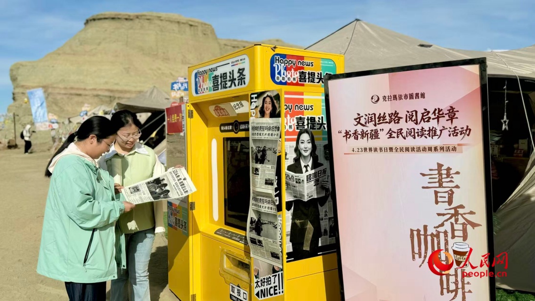 游客在“书香旅行”帐篷区翻阅本土作家作品，并自拍留念。人民网 李龙摄