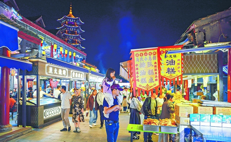 5月1日，华灯初上，游客在昌吉小吃街品美食、赏夜景，尽享假日休闲时光。 杨斌摄